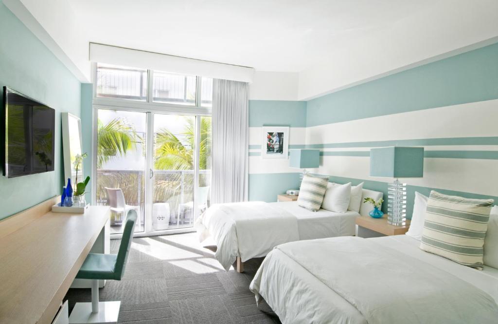 迈阿密海滩The Local House的一间卧室设有两张床、一张桌子和一个窗口。