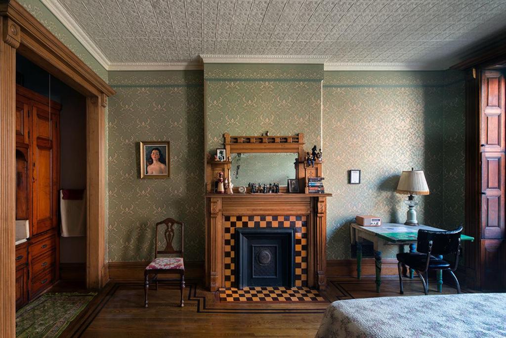 纽约哈林福罗普小屋酒店的一间卧室设有壁炉、桌子和床。