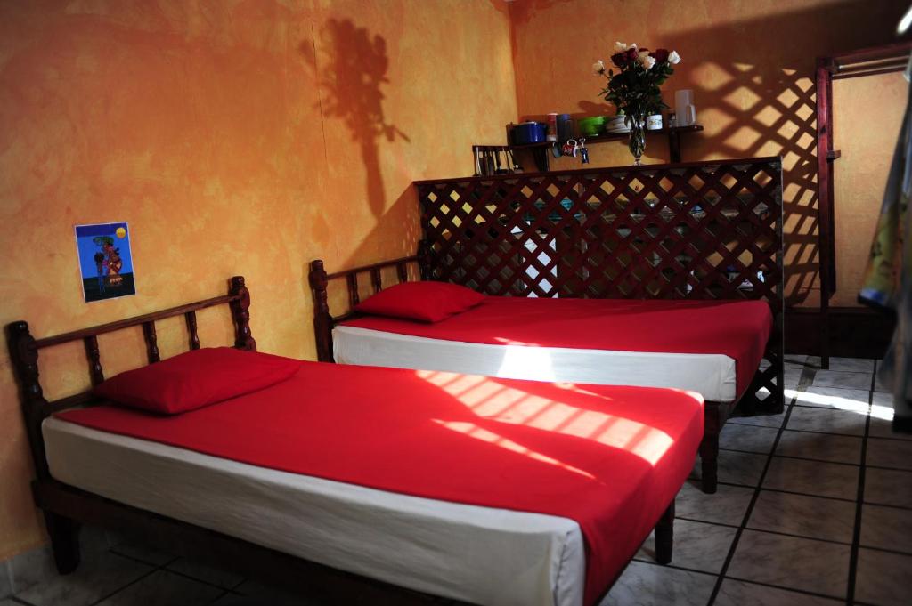 普拉亚卡门Hotel Colorado的红色床单的客房内的两张床