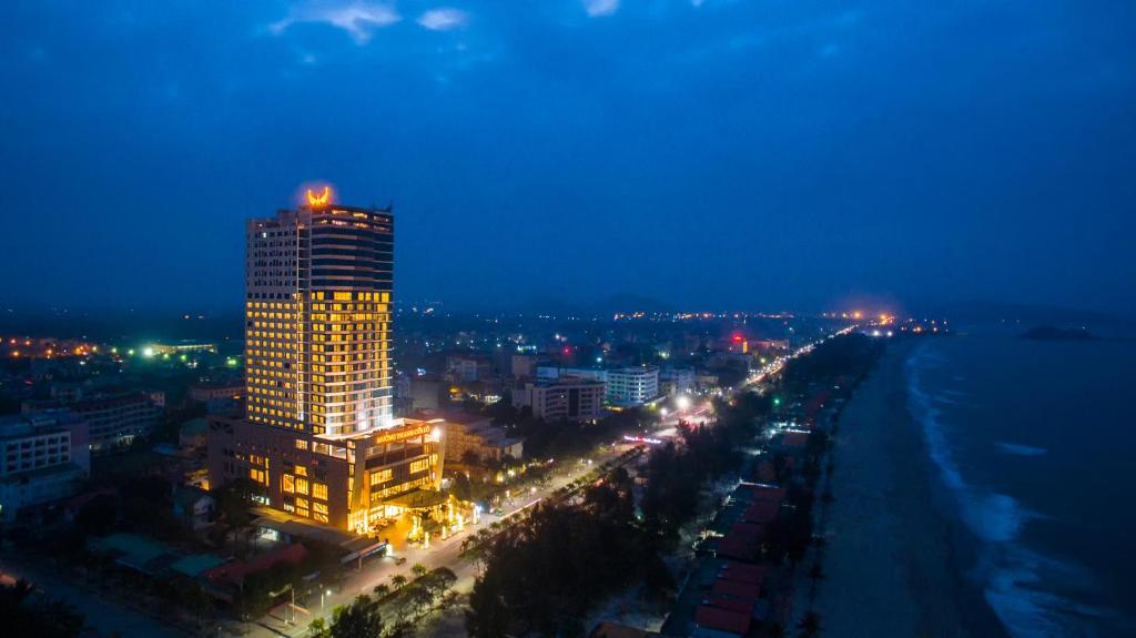 格卢市社孟青格兰德库阿尔酒店的一座高大的建筑,上面有灯,晚上