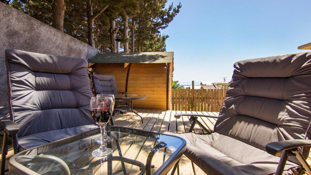 皮奇勒姆Comarca Lodge的露台的玻璃桌旁的一杯葡萄酒