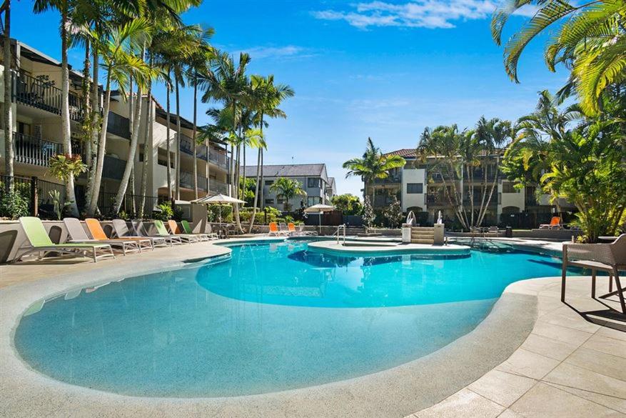 努萨角努萨海德兹哈斯廷法国度假胜地努萨海滩公寓的一个带椅子和棕榈树的大型游泳池