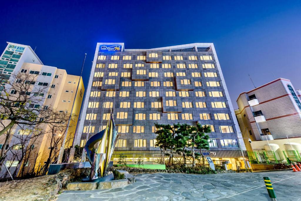 西归浦市The First70 Hotel的夜晚在城市的高楼