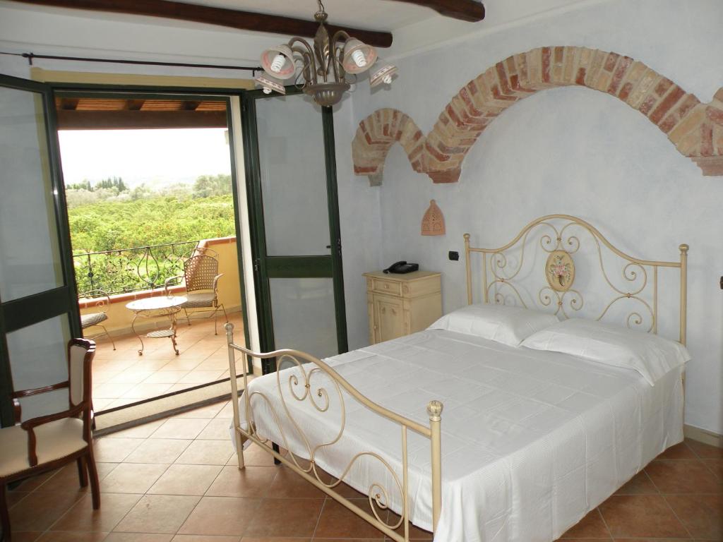 托尔托利Agriturismo Su Canonigu的一间带白色床的卧室和一个阳台