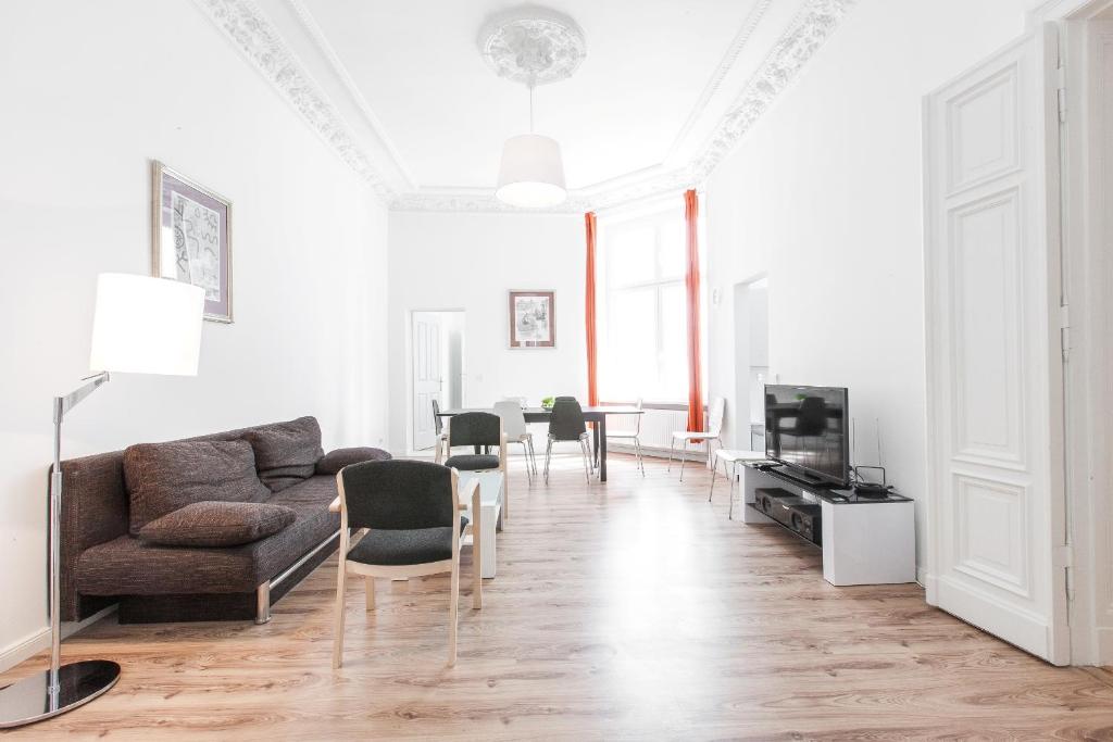 柏林柏林市区豪华公寓的客厅配有沙发、椅子和电视