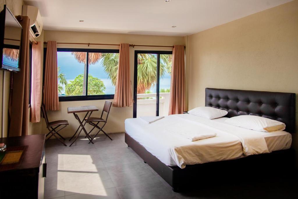 乔木提恩海滩GI旅馆的一间卧室配有一张大床、一张书桌和窗户。