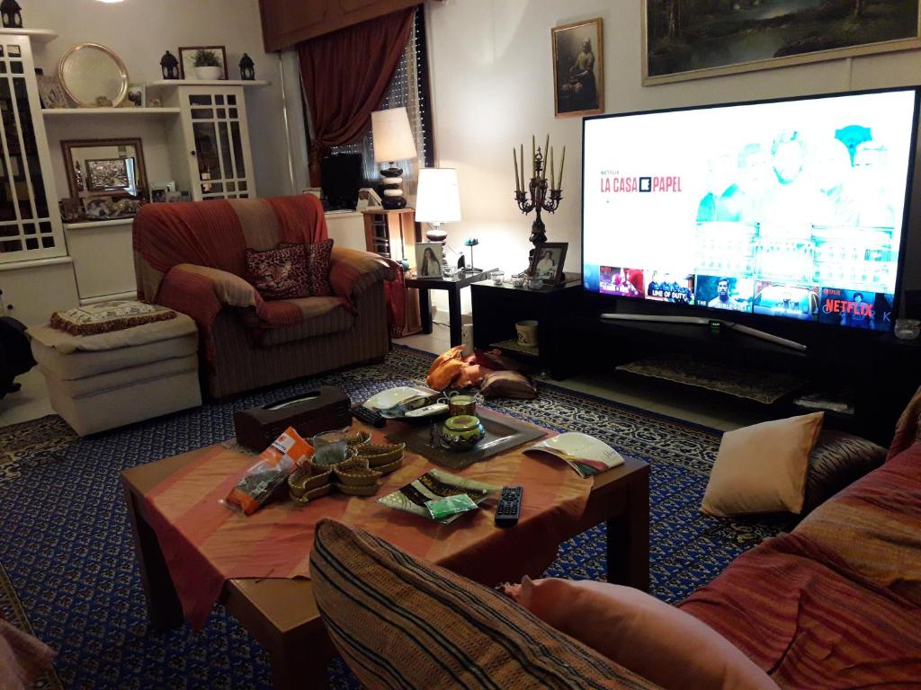 利马索尔Shared Top 1st floor villa的客厅配有大电视和桌子