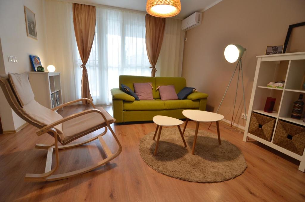 蒂米什瓦拉AVA Apartments ADORA FOREST 1的客厅配有绿色沙发和2张桌子