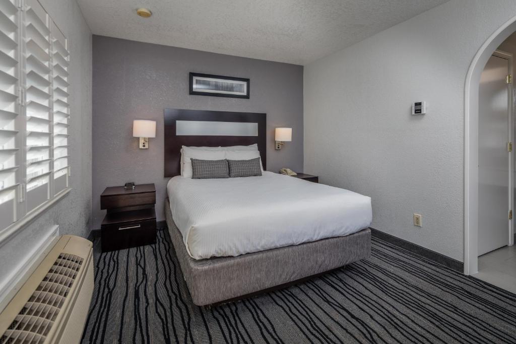 红木城红木溪汽车旅馆的卧室设有一张白色大床和一扇窗户。