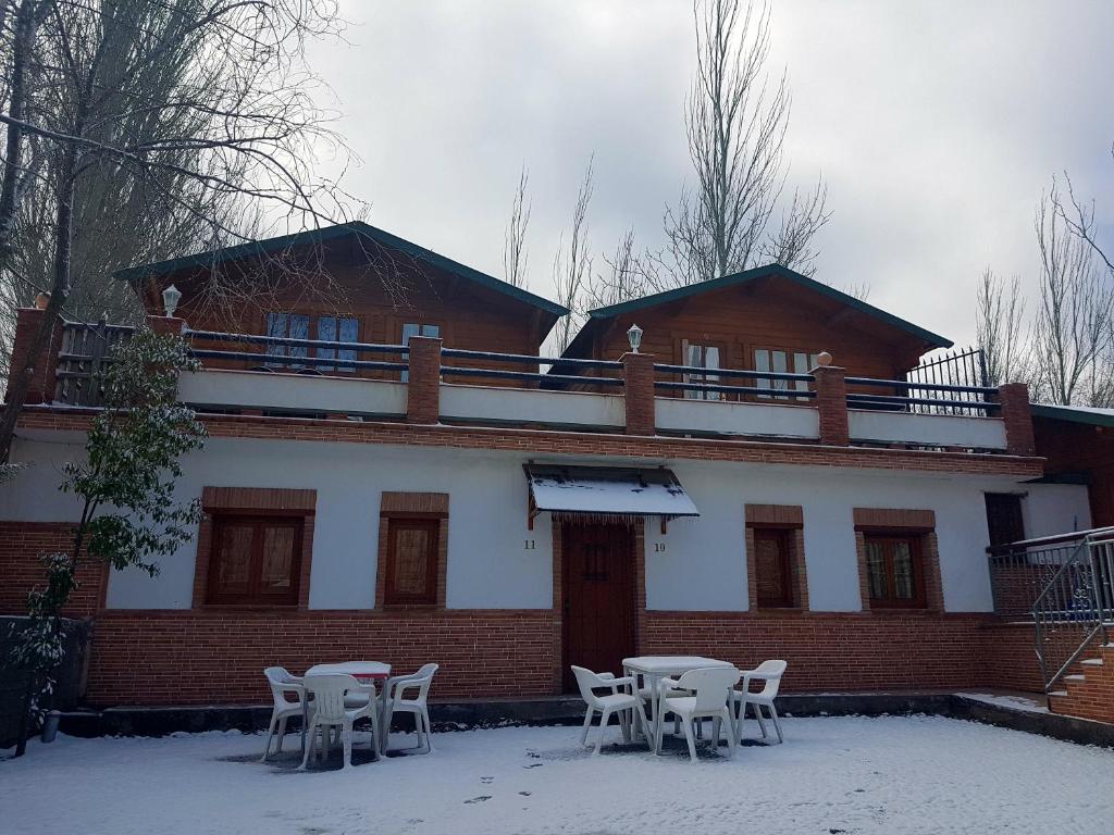 莫纳奇尔鲁塔德尔浦尔斯克营地酒店的雪地里带桌椅的建筑