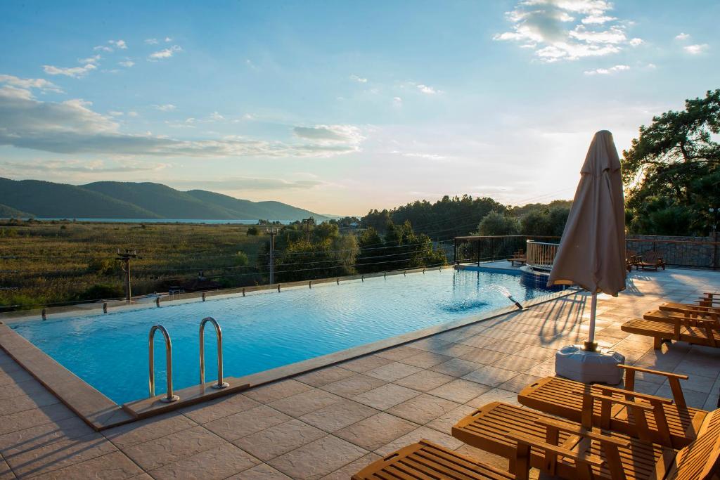 阿奇亚卡Grand Hotel Azmakhan Spa&Welness的一个带椅子和遮阳伞的大型游泳池