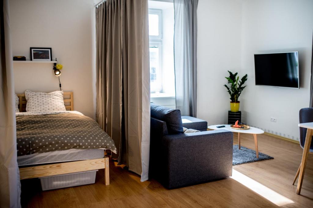 顺佩尔克Apartmán v centru的一间卧室配有一张床、一把椅子和电视。