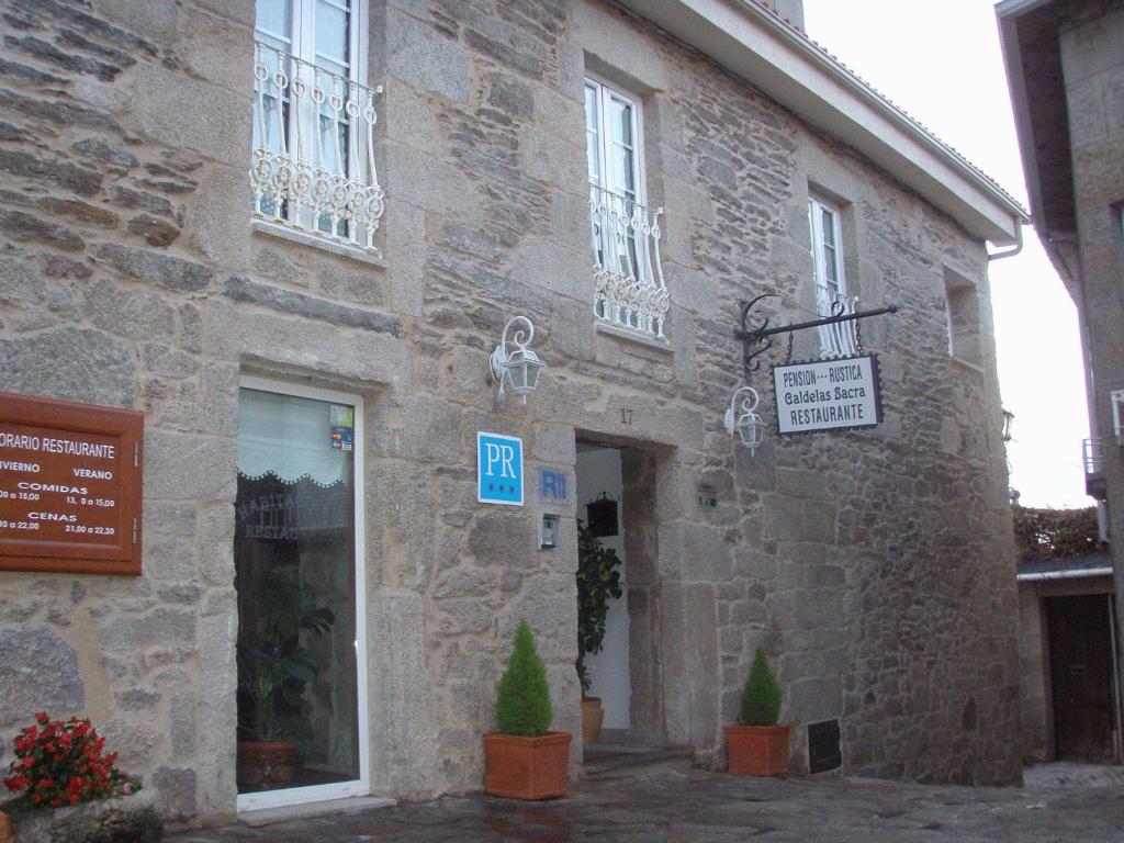 卡斯特罗卡尔德拉斯鲁斯提卡卡尔德拉斯萨克拉旅馆的一座石头建筑,旁边设有标志