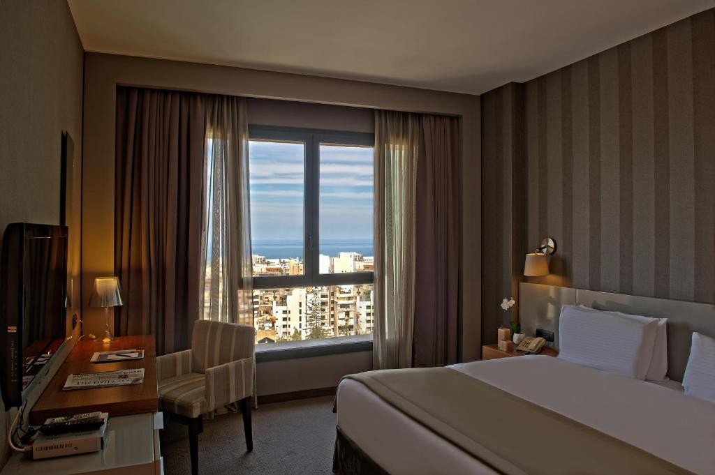 贝鲁特公园塔套房酒店的配有一张床、一张书桌和一扇窗户的酒店客房