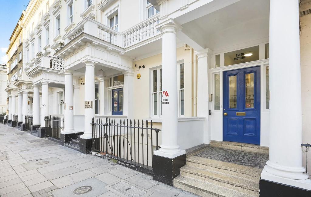 伦敦阿斯特维多利亚旅舍的一排带有蓝色门的白色建筑