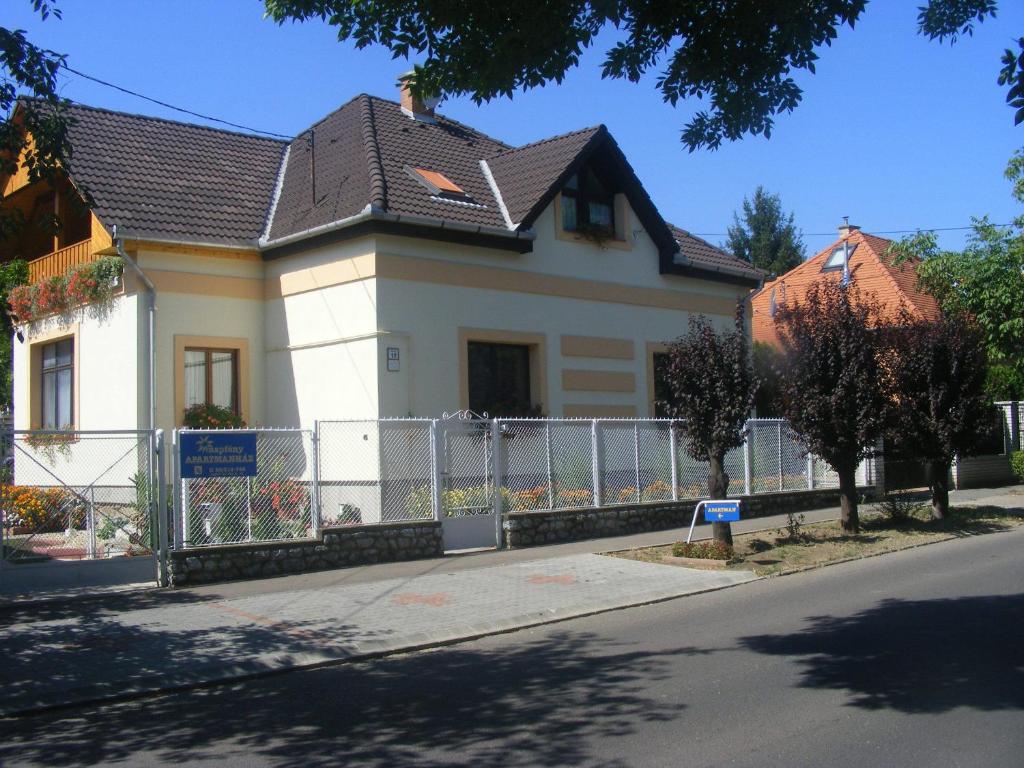 埃格尔Napfény Apartmanház的街道上带围栏的白色房屋