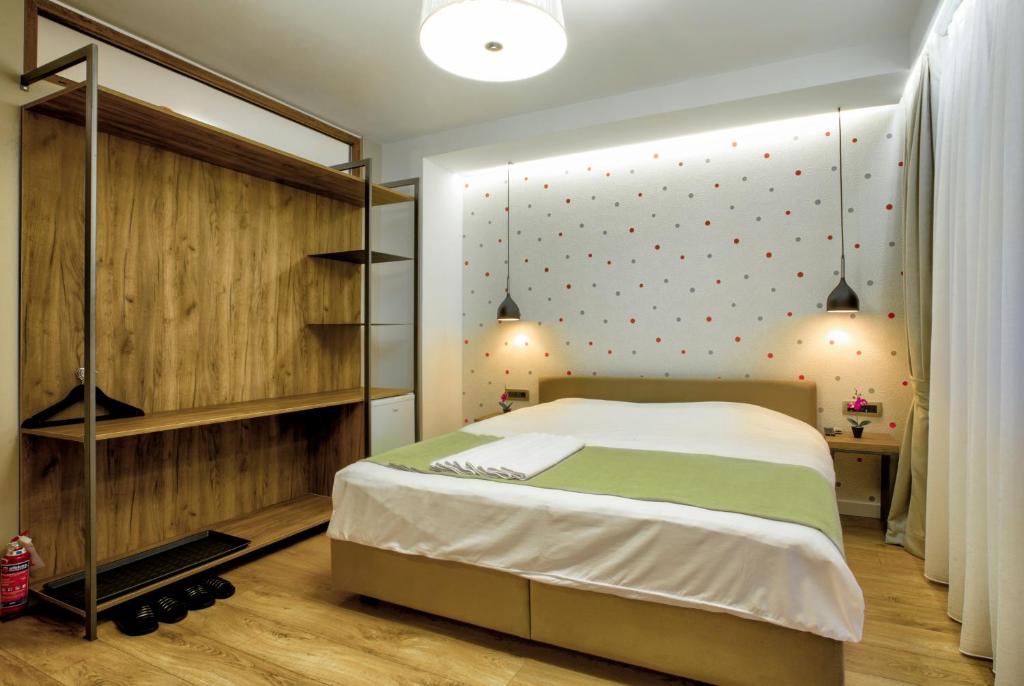 普里什蒂纳Boulevard Prishtina的一间卧室配有一张床,墙上配有波卡点