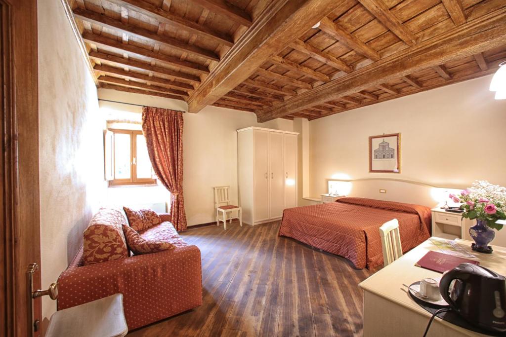 卡尔米尼亚诺Hotel Villa San Michele的酒店客房,配有床和沙发