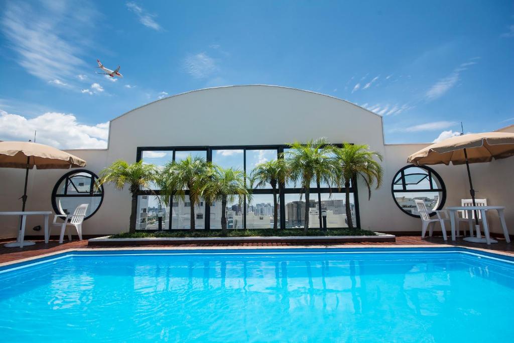 圣保罗特苏宫公寓酒店的一座棕榈树游泳池和一座建筑