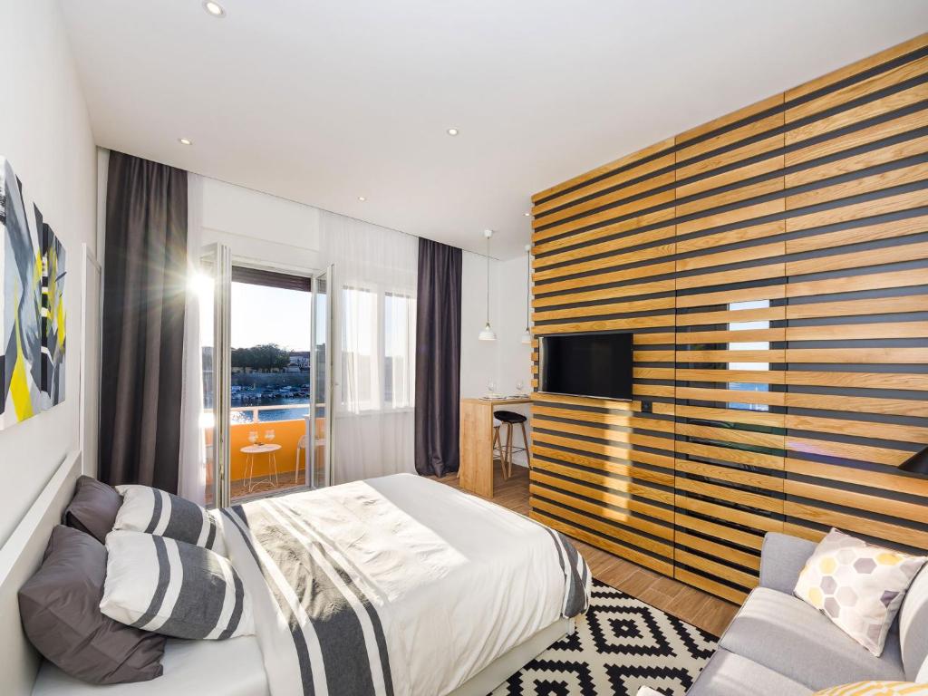 扎达尔Apartments Withlove Zadar的一间卧室配有一张床、一台电视和一张沙发