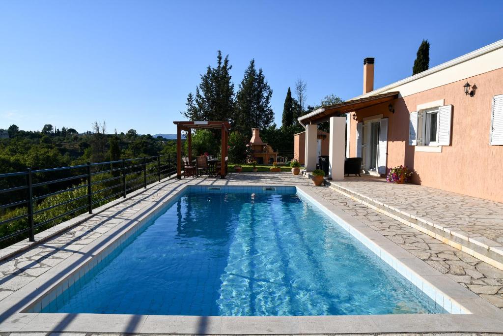 科孚镇Villa Sophia的房屋前的游泳池