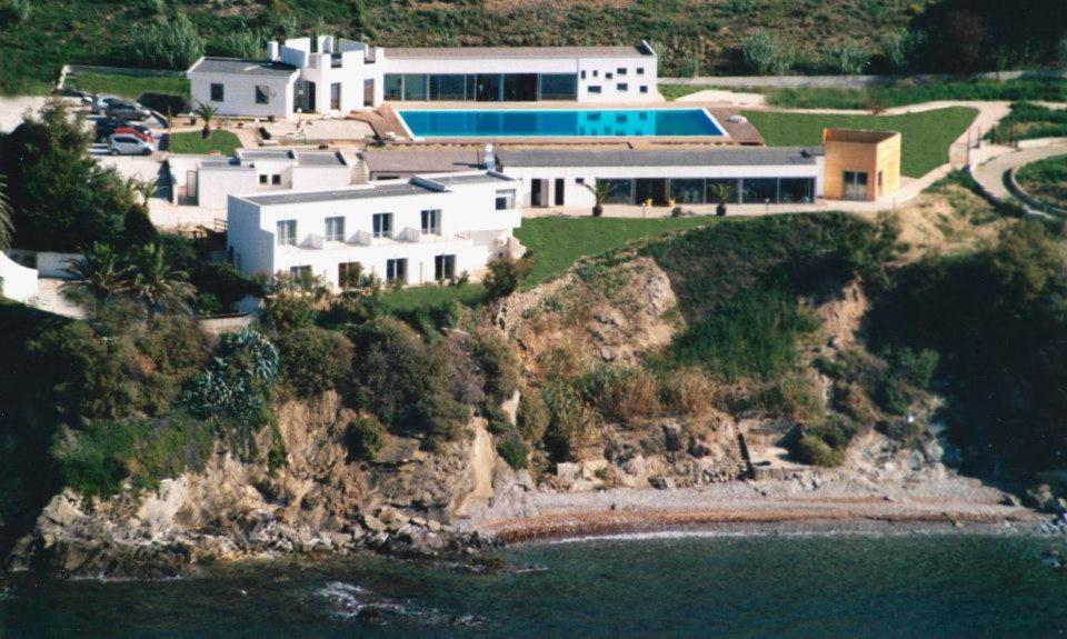 皮昂比诺La Rosa dei Venti Resort的水边悬崖上的房屋
