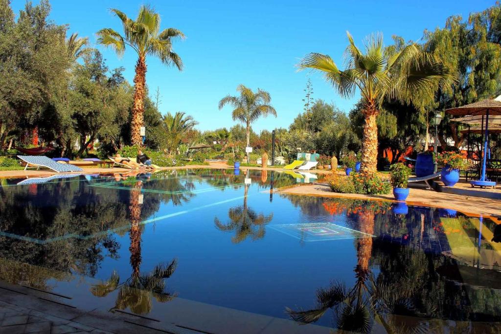 马拉喀什勒雷莱斯德马拉喀什酒店的公园内种有棕榈树的大型游泳池