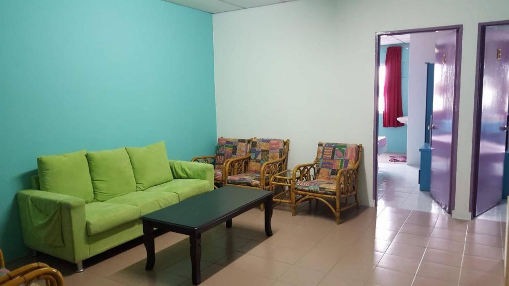 马六甲古城酒店的客厅配有绿色沙发和椅子