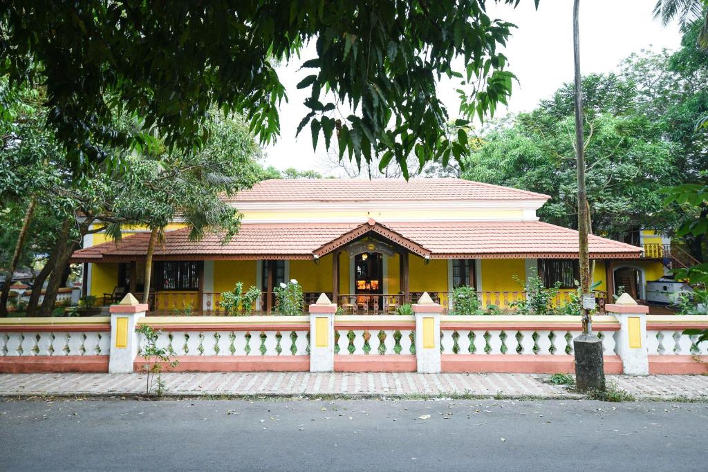 帕纳吉Surya Kiran Heritage Hotel的前面有栅栏的黄色房子