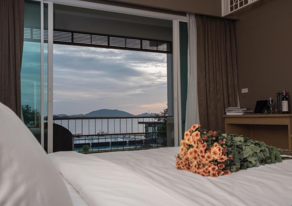 尖竹汶班里姆奥酒店的一间卧室设有一张床和一个大窗户