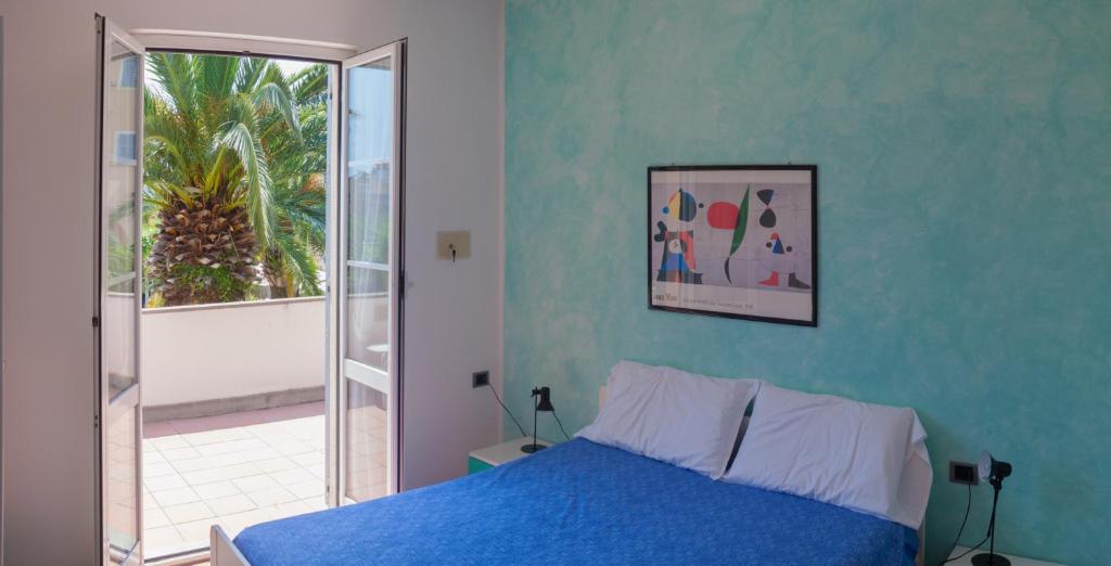 皮特拉利古Residence Pian Dei Boschi的蓝色的卧室设有床和窗户