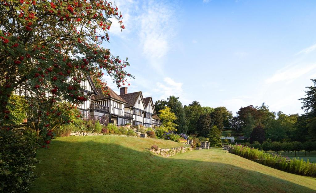 查格福德Gidleigh Park- A Relais & Chateaux Hotel的一座大房子,位于一座小山上,拥有绿色庭院