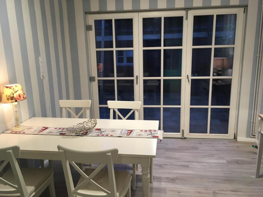 埃姆登Ferienhaus Witte Huuske的窗户客房内的白色桌椅