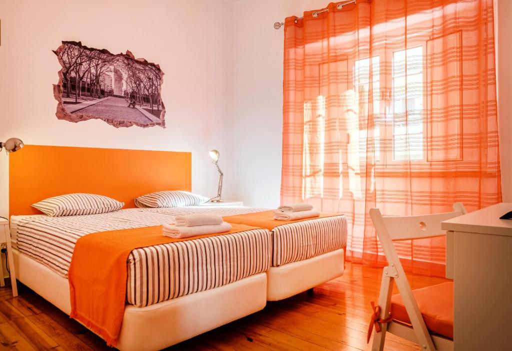 楼尔Loulé Coreto Hostel的一间卧室配有一张带橙色床头板和窗户的床。