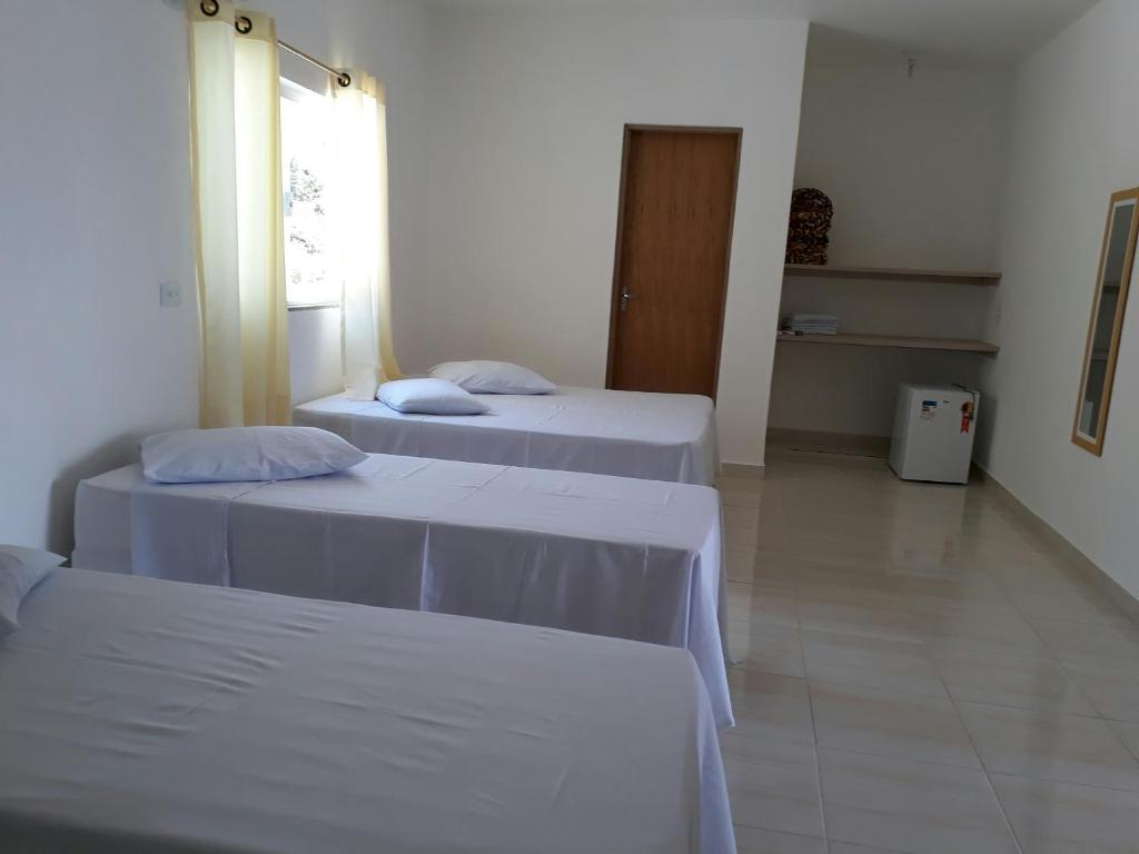 阿帕雷西达Pousada GEF Aparecida的客房设有2张带白色床单的床和窗户。