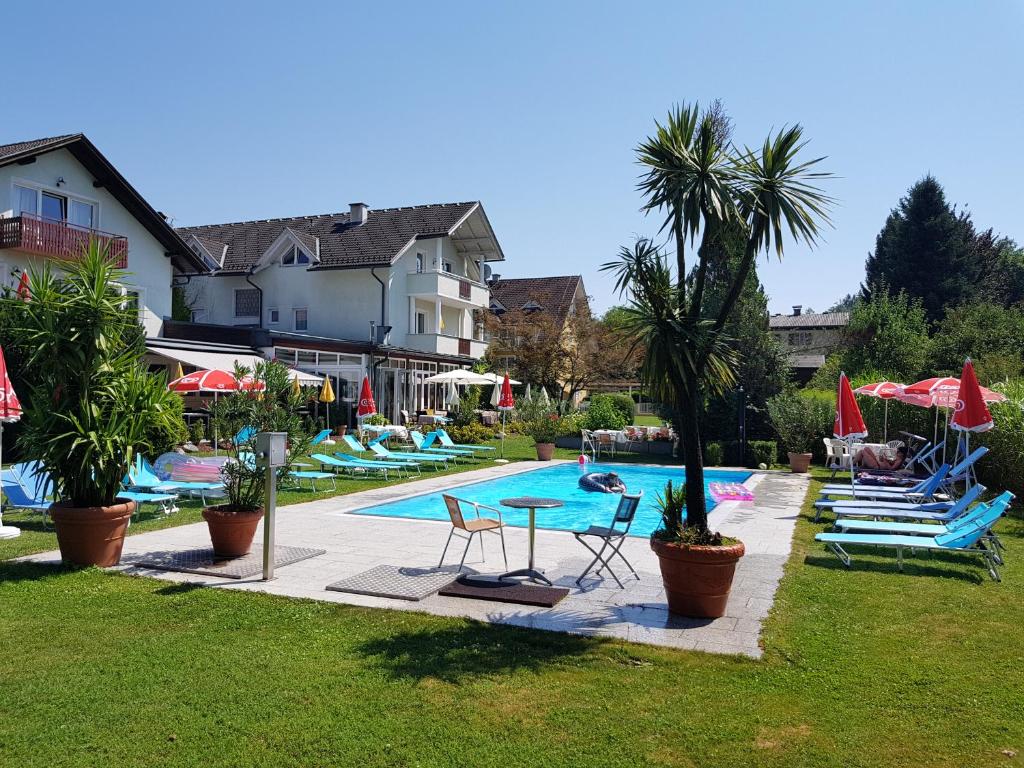 沃尔特湖畔韦尔登弗洛拉别墅酒店的度假村内带椅子和遮阳伞的游泳池