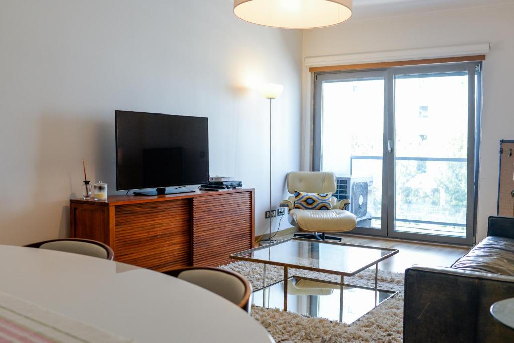 里斯本Lisbon White Cozy Apartment的客厅配有平面电视和沙发。