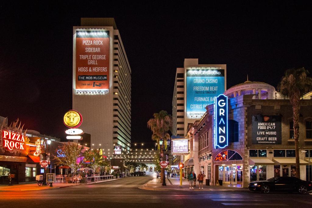 拉斯维加斯Downtown Grand Hotel & Casino的夜间有建筑和标志的城市街道