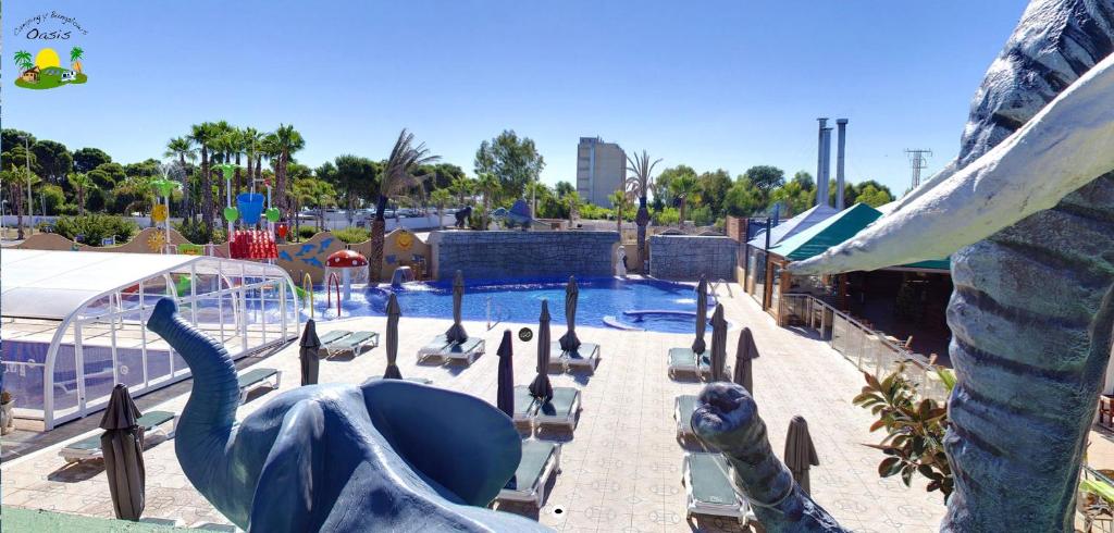 奥罗佩萨德尔马露营及简易别墅绿洲酒店的一个带游泳池和恐龙雕像的水上公园