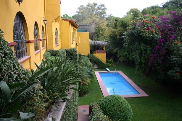 库埃纳瓦卡Casa Madero Rooms的一座花园,在一座建筑前设有一个游泳池