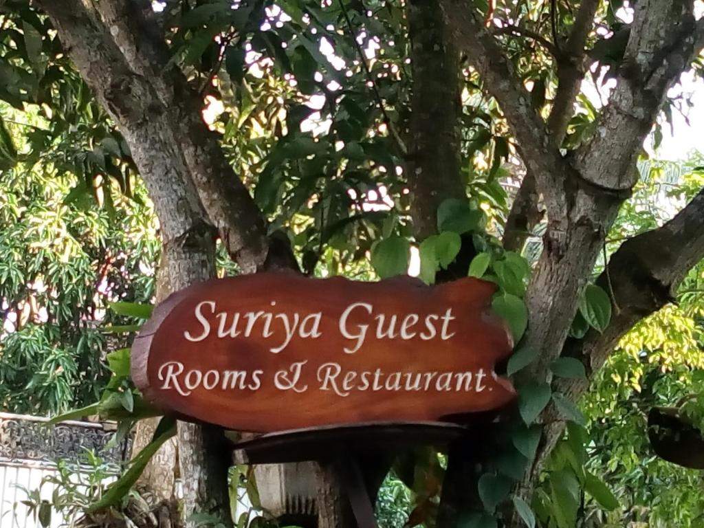 米瑞莎Suriya Homestay Mirissa的树旁客房和餐厅的标志