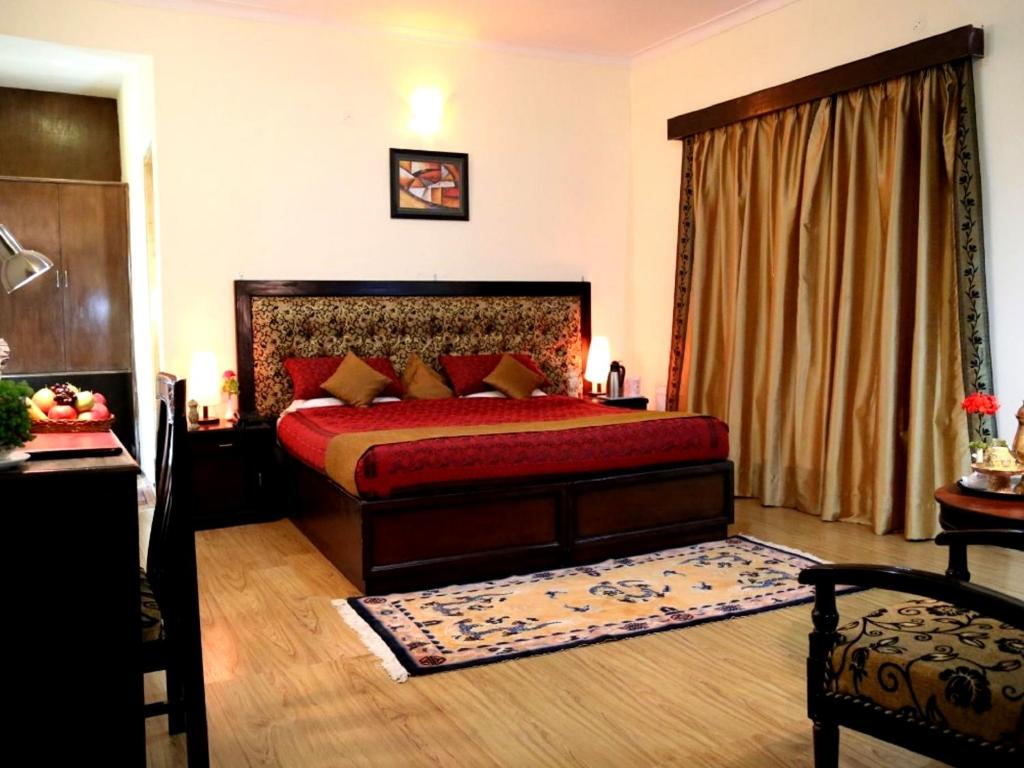 列城Hotel Royal Palace - Leh的一间卧室配有一张红色床罩的床