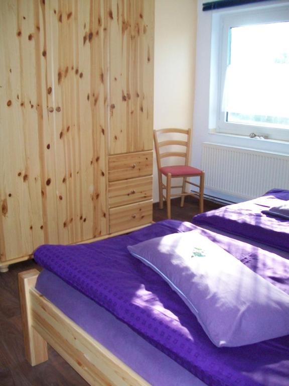 AnkeloheHaus Darmstadt的一间卧室设有两张床、一把椅子和一个窗户。