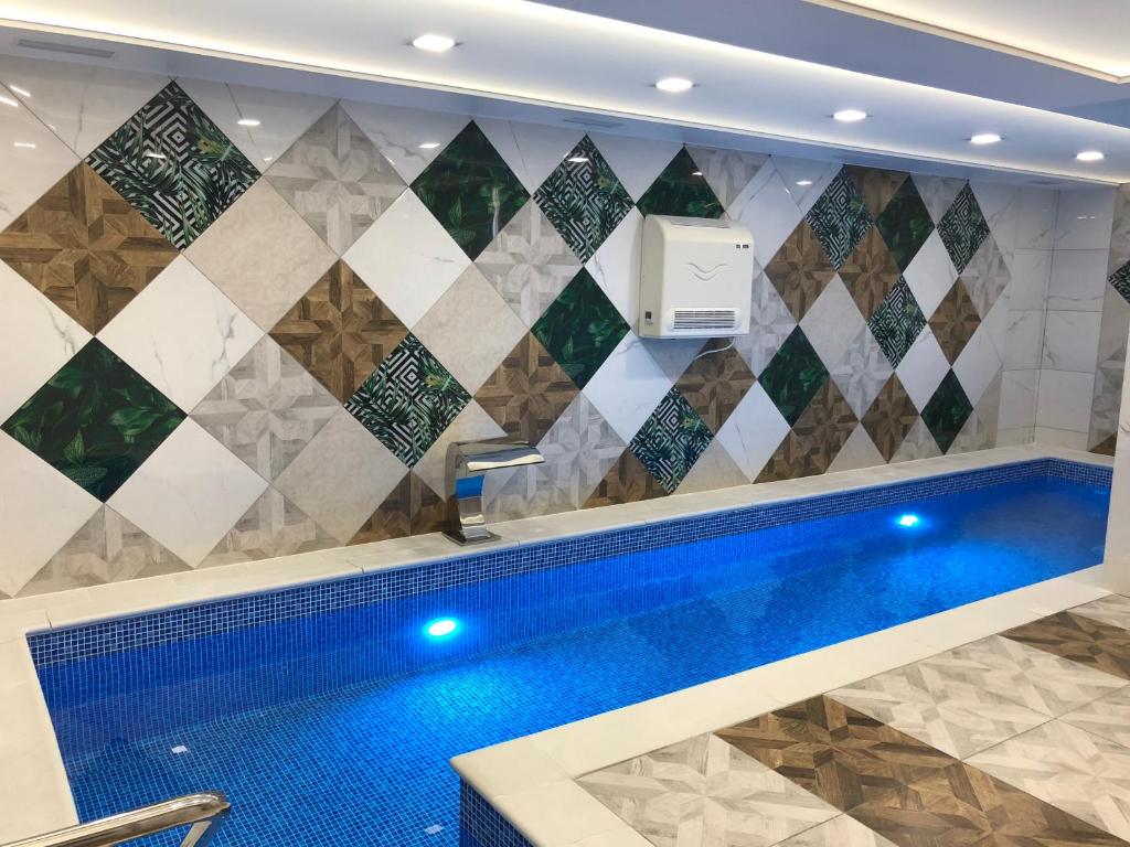 亚列姆切Premier的一座带瓷砖墙的房子内的游泳池