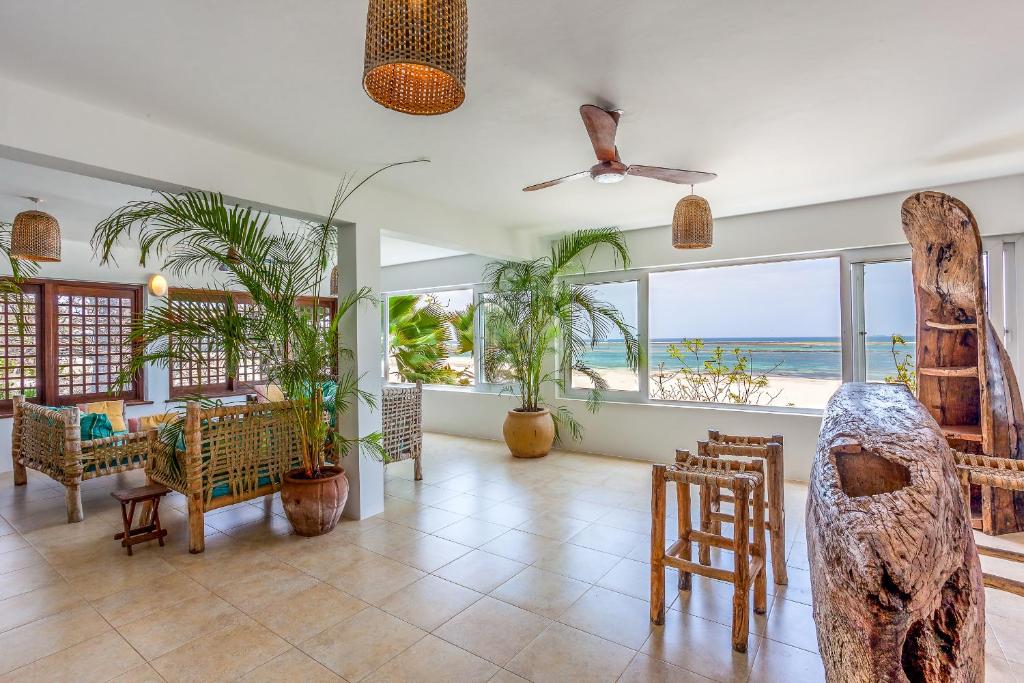 迪亚尼海滩Tequila Sunrise Beach Cabana - Diani Beach的客厅配有桌椅和窗户。