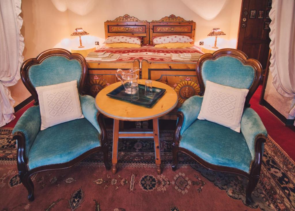 Ala di SturaLa Crestolina的一间卧室配有一张带桌子和两把椅子的床