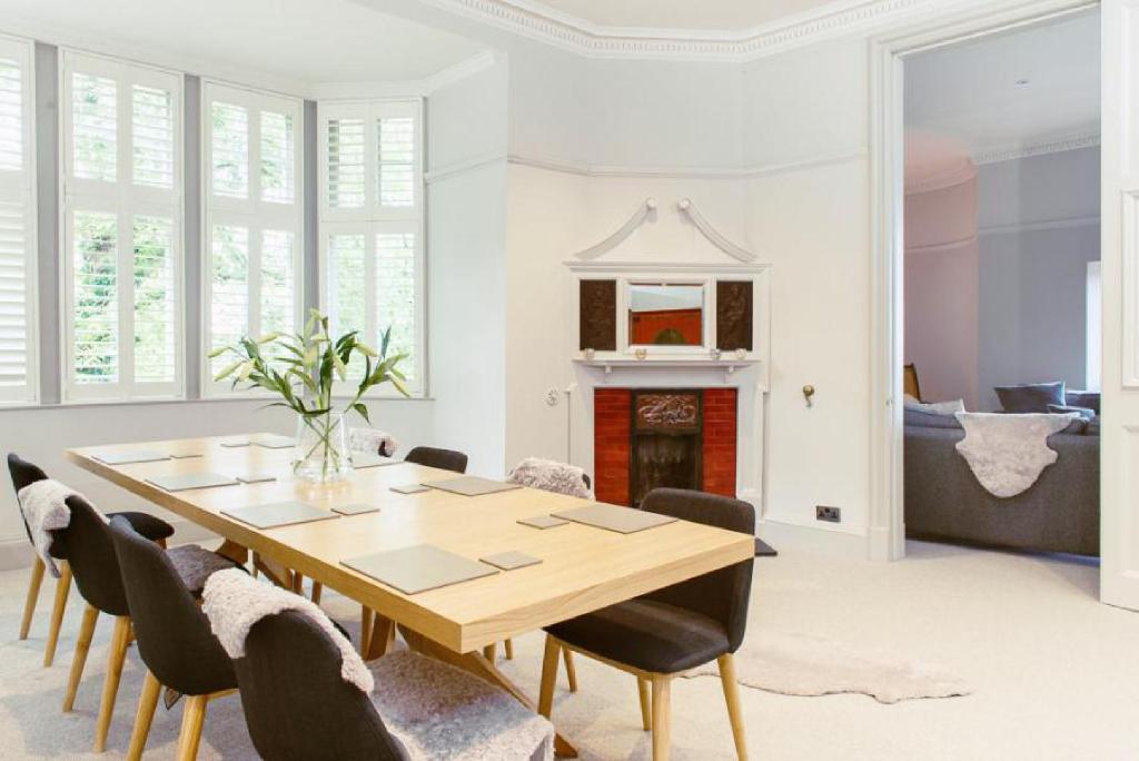 爱丁堡Ramsay Gardens - Grand 4-Bedroom Apartment Next To Castle的一间带木桌和椅子的用餐室