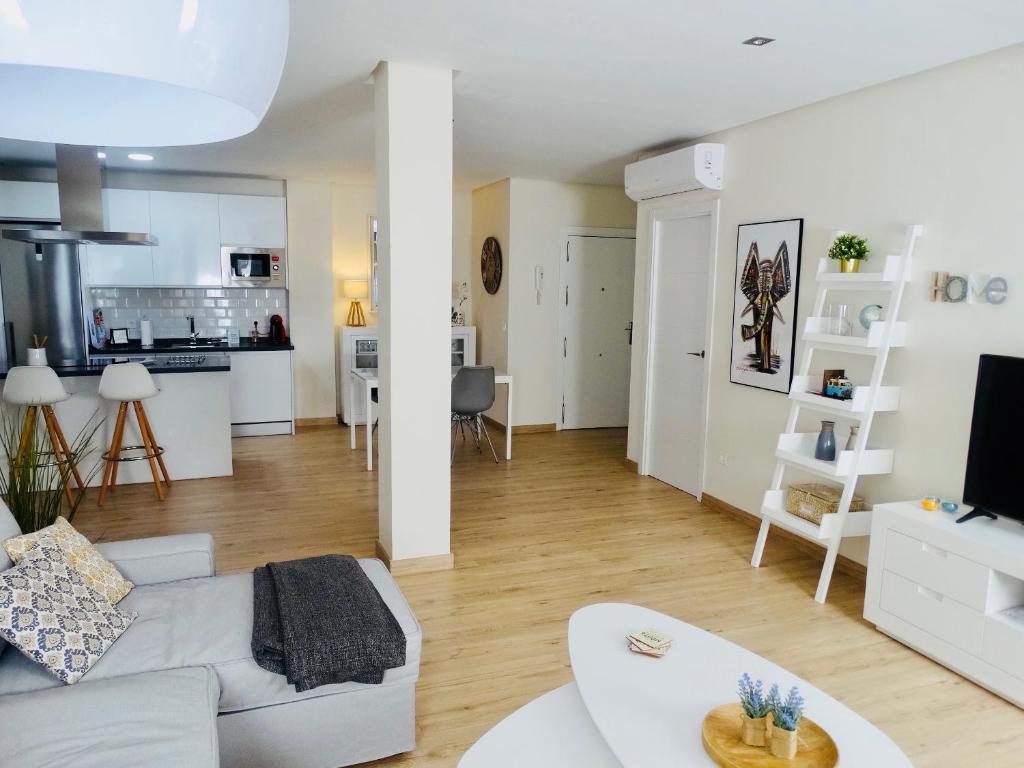 塞维利亚Apartamento El Barranco的一间带白色沙发的客厅和一间厨房