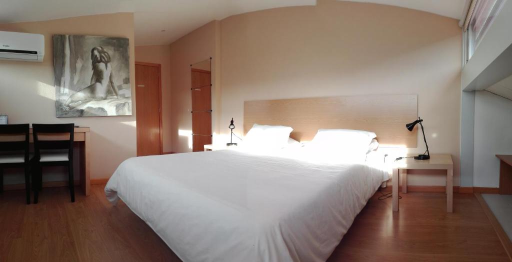沃泽拉Penthouse - Low Cost的卧室配有一张白色的大床和一张桌子