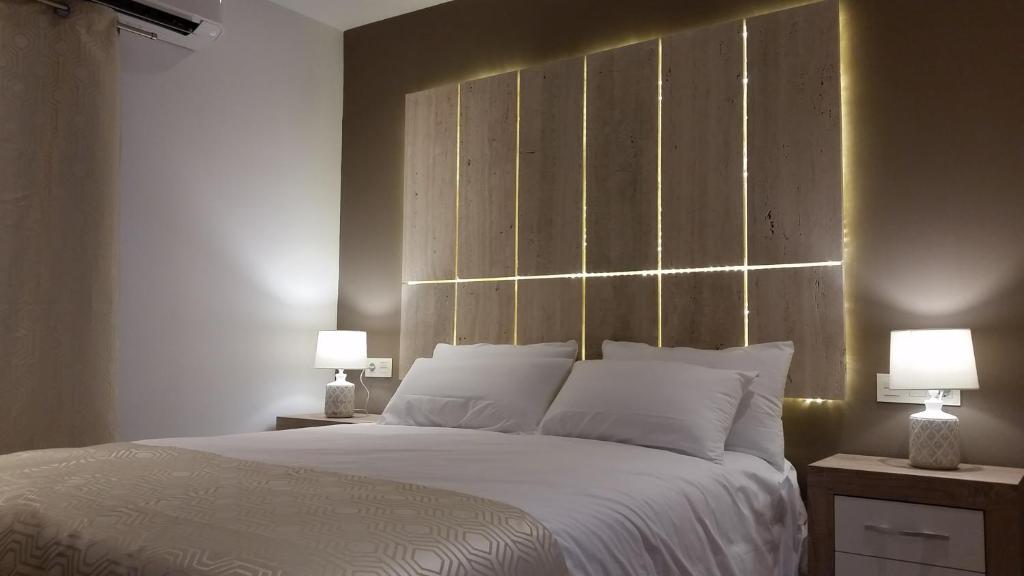 马贝拉Lucero 12的一间卧室配有一张带两盏灯的大型白色床。